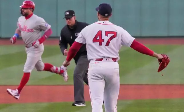 Boston Red Sox pitcher Jovani Moran (47) watches Philadelphia Phillies designated hitter Kyle Schwarber rounds the bases on a solo home run during the first inning of a baseball game, Tuesday, May 12, 2026, in Boston. (AP Photo/Charles Krupa)