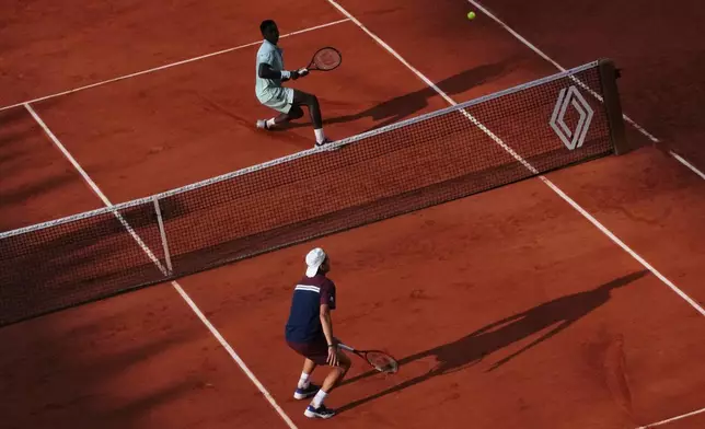 Alejandro Tabilo of Chile, bottom, plays against Moise Kouame of France during their third round men's singles tennis match at the French Open tennis tournament in Paris, Saturday, May 30, 2026. (AP Photo/Christophe Ena)