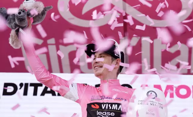 Denmark's Jonas Vingegaard wears the pink jersey of the race overall leader as he celebrates winning the 16th stage of the Giro d'Italia cycling race from Bellinzona to Cari', Switzerland, Tuesday May 26, 2026. (Massimo Paolone/LaPresse via AP)