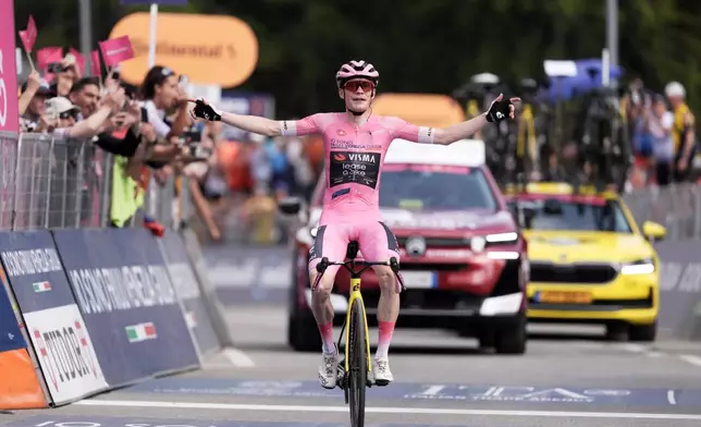 Denmark's Jonas Vingegaard wears the pink jersey of the race overall leader, celebrates winning the 16th stage of the Giro d'Italia cycling race from Bellinzona to Cari', Switzerland, Tuesday May 26, 2026. (Massimo Paolone/LaPresse via AP)