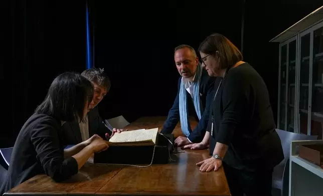From left, Elisabetta Magnanti, Mark Faulkner of Dublin's Trinity College, Andrea Cappa and Valentina Longo of Rome's National Central Library examine a manuscript containing a rare, long-lost copy of Caedmon's Hymn — the first poem ever written down in Old English — at Rome's National Library, Thursday, May 8, 2026. (AP Photo/Andrea Rosa)