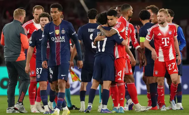 Bayern's Luis Diaz, center right, and PSG's Vitinha embrace at the end of a Champions League semifinal, first leg, soccer match between Paris Saint-Germain and Bayern Munich in Paris, Tuesday, April 28, 2026. (AP Photo/Aurelien Morissard)
