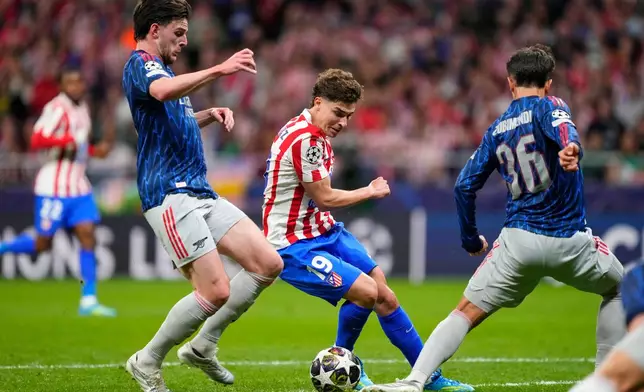 Atletico Madrid's Julian Alvarez, center, is challenged by Arsenal's Declan Rice during a Champions League semifinal, first leg, soccer match between Atletico Madrid and Arsenal in Madrid, Spain, Wednesday, April 29, 2026. (AP Photo/Jose Breton)