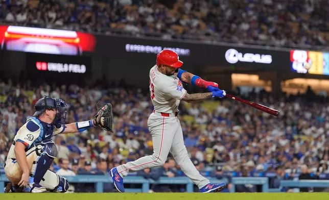 Philadelphia Phillies' Edmundo Sosa, right, hits a two-run home run as Los Angeles Dodgers catcher Will Smith watches during the eighth inning of a baseball game Saturday, May 30, 2026, in Los Angeles. (AP Photo/Mark J. Terrill)