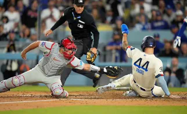 Los Angeles Dodgers' Andy Pages, right, scores on a single by Mookie Betts under the tag of Philadelphia Phillies catcher J.T. Realmuto during the seventhninning of a baseball game Saturday, May 30, 2026, in Los Angeles. (AP Photo/Mark J. Terrill)