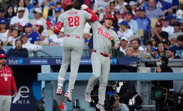 Philadelphia Phillies' Alec Bohm, left, celebrates his solo home run with J.T. Realmuto, during the second inning of a baseball game against the Los Angeles Dodgers, Saturday, May 30, 2026, in Los Angeles. (AP Photo/Mark J. Terrill)