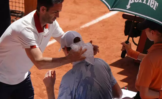 Jannik Sinner of Italy receives medical assistance during a break at the second round men's singles tennis match against Juan Manuel Cerundolo of Argentina at the French Open tennis tournament in Paris, Thursday, May 28, 2026. (AP Photo/Aurelien Morissard)