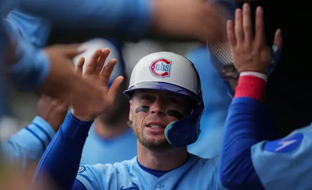 Chicago Cubs' Nico Hoerner (2) celebrates in the dugout after scoring on a single by Michael Busch during the first inning of a baseball game against the Arizona Diamondbacks, Friday, May 1, 2026, in Chicago. (AP Photo/Erin Hooley)