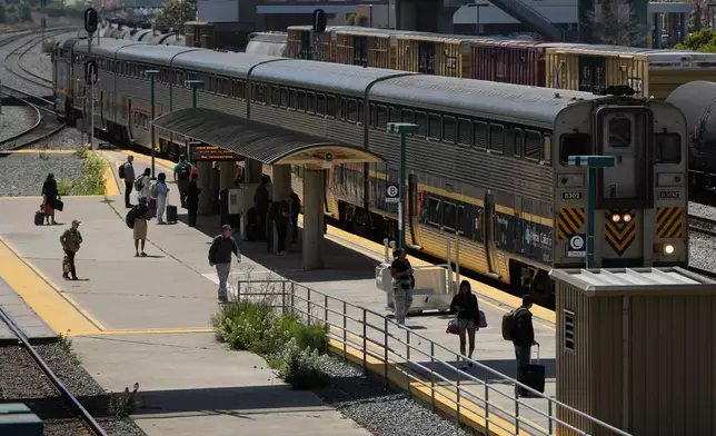 Passengers wait to board an Amtrak train at a station in Emeryville, Calif., Thursday, April 30, 2026. (AP Photo/Jeff Chiu)