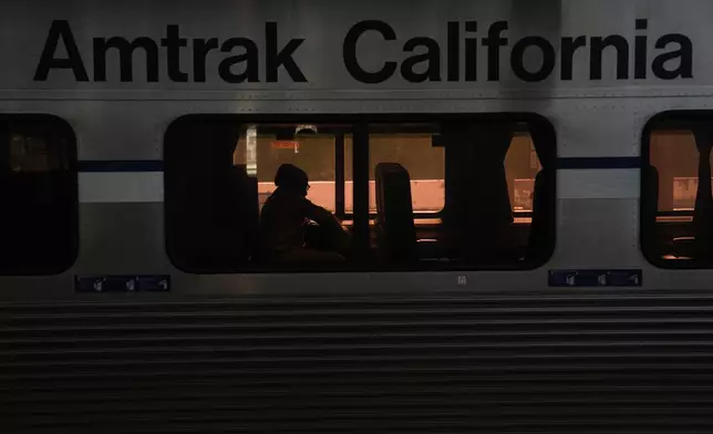 A passenger sits aboard an Amtrak train at Union Station in Los Angeles, Thursday, April 30, 2026. (AP Photo/Jae C. Hong)