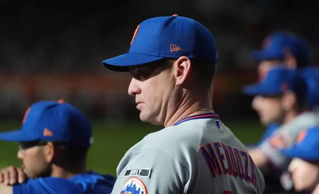 New York Mets manager Carlos Mendoza watches the action on the field during the third inning of a baseball game against the Arizona Diamondbacks, Saturday, May 9, 2026, in Phoenix. (AP Photo/Ross D. Franklin)