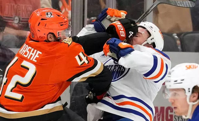 Anaheim Ducks center Tim Washe, left, puts a hit on Edmonton Oilers defenseman Ty Emberson during the second period of Game 6 in the first round of the NHL hockey Stanley Cup playoffs series Thursday, April 30, 2026, in Anaheim, Calif. (AP Photo/Mark J. Terrill)