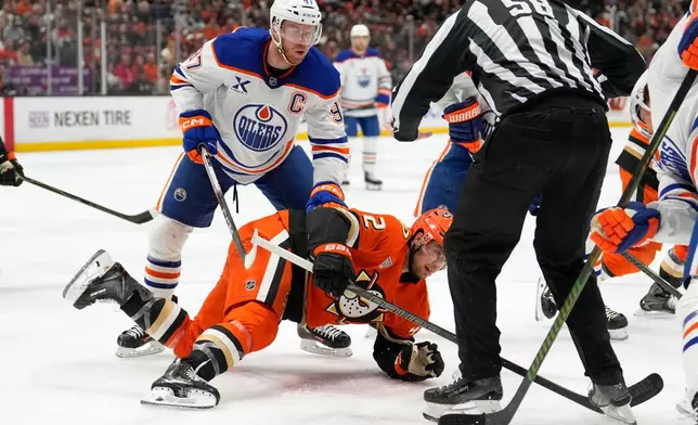 Edmonton Oilers center Connor McDavid, left, and Anaheim Ducks center Tim Washe go after the puck on a face-off during the second period of Game 6 in the first round of the NHL hockey Stanley Cup playoffs series Thursday, April 30, 2026, in Anaheim, Calif. (AP Photo/Mark J. Terrill)