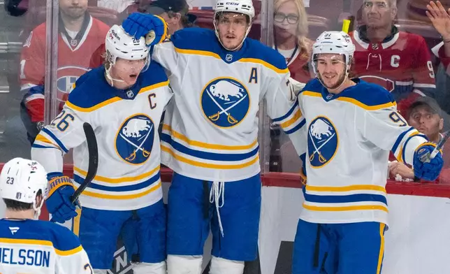 Buffalo Sabres' Tage Thompson, center, celebrates his goal with teammates Rasmus Dahlin (26) and Josh Doan (91) during the first period in Game 3 in a second-round NHL hockey Stanley Cup playoff series against the Montreal Canadiens in Montreal, Sunday, May 10, 2026. (Christinne Muschi/The Canadian Press via AP)