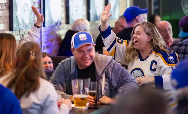 Buffalo Sabres fans celebrate a goal while watching Stanley Cup second-round playoff action against the Montreal Canadiens at Kully's Original Sports Bar in St. Catharines, on Wednesday, May 6, 2026. (Nick Iwanyshyn/The Canadian Press via AP)