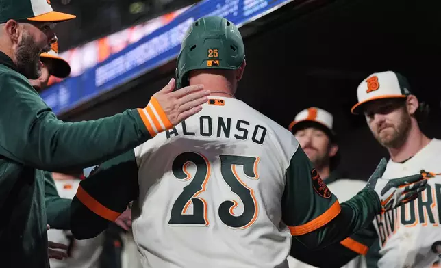 Baltimore Orioles' Pete Alonso (25) celebrates with teammates in the dugout after hitting a three-run home run during the third inning of a baseball game against the Detroit Tigers, Friday, May 22, 2026, in Baltimore. (AP Photo/Stephanie Scarbrough)