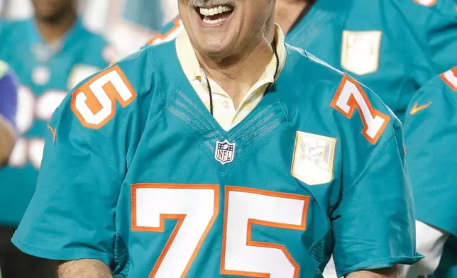 FILE - Former Miami Dolphins player Manny Fernandez smiles after being presented with a football during the Dolphins All-Time 50th Anniversary Team ceremony during half time at an NFL football game against the New York Giants, Dec. 14, 2015, in Miami Gardens, Fla. (AP Photo/Lynne Sladky, File)