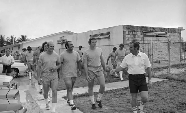 FILE - Miami Dolphins football coach Don Shula, right, leads, from left, safety Dick Anderson, defensive tackle Manny Fernandez and defensive end Bill Stanfield, to the practice field on July 11, 1973 in Miami, for the first day of workouts for the 1973 season.( AP Photo/Jim Kerlin, File)