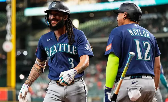 Seattle Mariners' J.P. Crawford (3) celebrates with Josh Naylor (12) after hitting a home run during the first inning of a baseball game against the Houston Astros in Houston, Wednesday, May 13, 2026. (AP Photo/Ashley Landis)