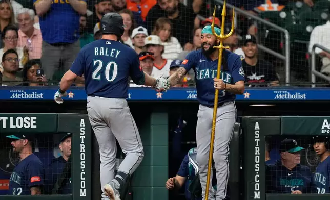 Seattle Mariners' Luke Raley (20) celebrates with J.P. Crawford (3) after hitting a home run during the sixth inning of a baseball game against the Houston Astros in Houston, Wednesday, May 13, 2026. (AP Photo/Ashley Landis)