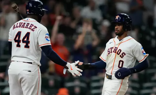 Houston Astros' Brice Matthews (0) celebrates with Yordan Alvarez after scoring during the eighth inning of a baseball game against the Seattle Mariners in Houston, Wednesday, May 13, 2026. (AP Photo/Ashley Landis)