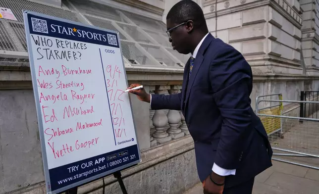 A bookmaker takes bets for a possible next British Prime Minister on his betting board near Downing Street in London, Tuesday, May 12, 2026.(AP Photo/Kirsty Wigglesworth)
