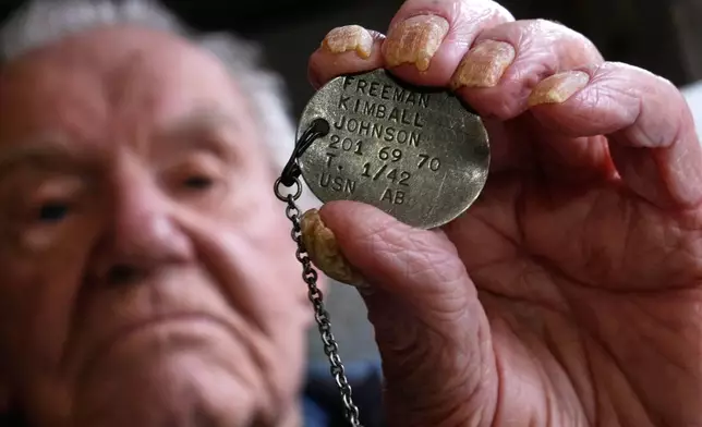 Freeman K. Johnson, a 106-year-old Pearl Harbor survivor, holds up his dog tag, May 6, 2026, in Centerville, Mass. (AP Photo/Charles Krupa)