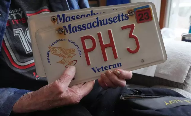 Freeman K. Johnson, a 106-year-old Pearl Harbor survivor, holds his veteran license plate during an interview at his home, May 6, 2026, in Centerville, Mass. (AP Photo/Charles Krupa)