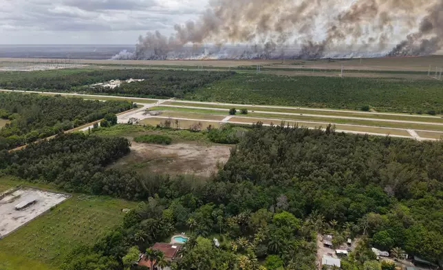 A wildfire burns Monday, May 11, 2026, in Broward County, Fla. (AP Photo/Daniel Kozin)