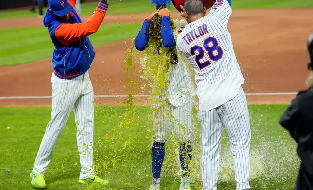 New York Mets' Carson Benge, center, is dunked with gatorade after hitting a walk-off RBI single during the tenth inning of a baseball game against the Detroit Tigers, Wednesday, May 13, 2026, in New York. (AP Photo/Yuki Iwamura)