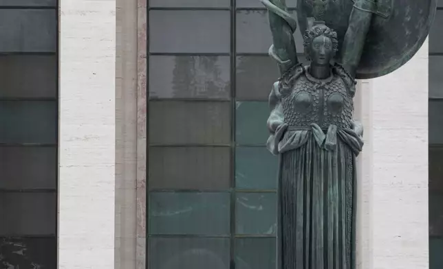 Pope Leo XIV is seen behind Arturo Martini's 1935 bronze statue of Minerva during a visit to Sapienza University of Rome's Città Universitaria campus to meet with faculty and students, Thursday, May 14, 2026. (AP Photo/Gregorio Borgia)