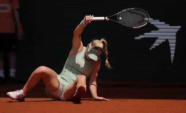 Emerson Jones of Australia falls down as she plays against Iga Swiatek of Poland during their first round women's singles tennis match at the French Open tennis tournament in Paris, Monday, May 25, 2026. (AP Photo/Thibault Camus)