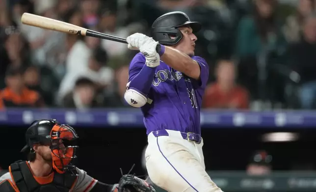 Colorado Rockies' Jake McCarthy follows the flight of his RBI single off San Francisco Giants relief pitcher Ryan Borucki in the seventh inning of a baseball game Saturday, May 30, 2026, in Denver. (AP Photo/David Zalubowski)