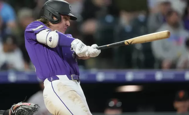 Colorado Rockies' Jake McCarthy connects for a two-run home run off San Francisco Giants starting pitcher Adrian Houser in the fourth inning of a baseball game Saturday, May 30, 2026, in Denver. (AP Photo/David Zalubowski)