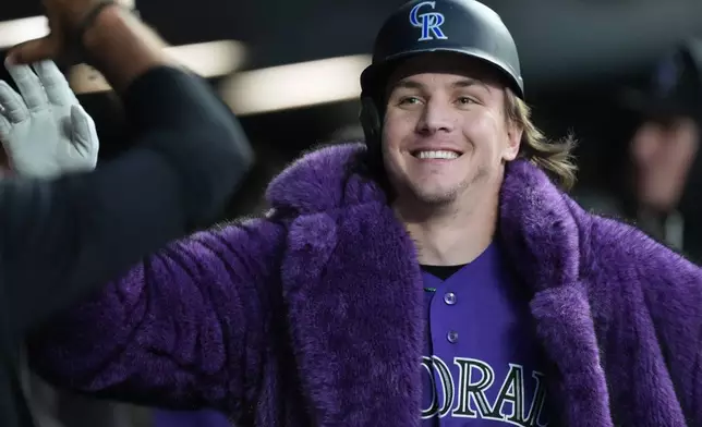 Colorado Rockies' Jake McCarthy is congratulated as he returns to the dugout after hitting a two-run home run off San Francisco Giants starting pitcher Adrian Houser in the fourth inning of a baseball game Saturday, May 30, 2026, in Denver. (AP Photo/David Zalubowski)
