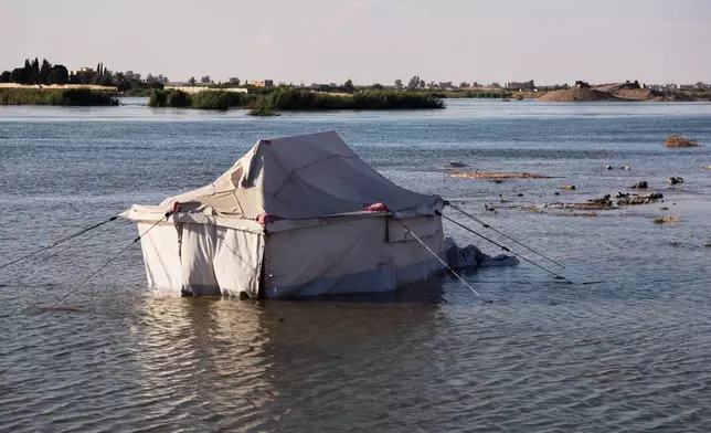 A tent belonging to displaced residents stands partially submerged in floodwaters along the banks of the Euphrates River near Raqqa, northeastern Syria, Tuesday, May 26, 2026. (AP Photo/Baderkhan Ahmad)