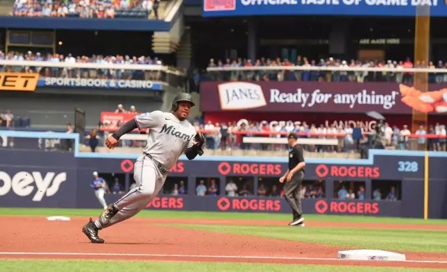 Miami Marlins' Xavier Edwards (9) rounds the bases before scoring on Otto Lopez's RBI single off Toronto Blue Jays pitcher Kevin Gausman during the first inning of a baseball game in Toronto, Wednesday, May 27, 2026. (Chris Young/The Canadian Press via AP)