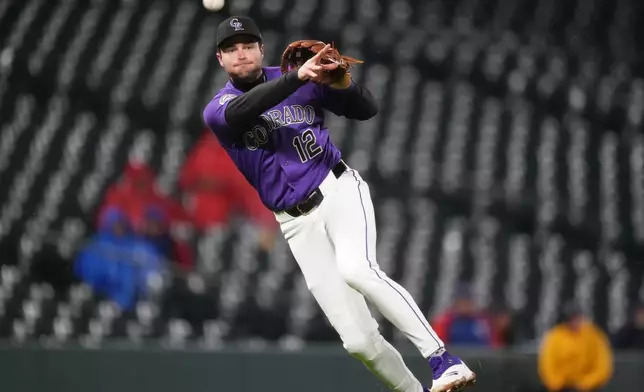 Colorado Rockies third baseman Kyle Karros throws to first base to put out Texas Rangers' Evan Carter in the eighth inning of a baseball game Monday, May 18, 2026, in Denver. (AP Photo/David Zalubowski)