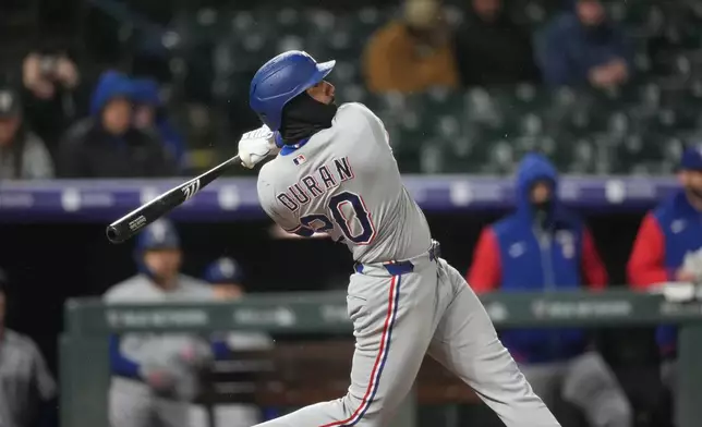 Texas Rangers' Ezequiel Duran follows the flight of his single taht drove in two runs off Colorado Rockies relief pitcher Brennan Bernardino in the eighth inning of a baseball game Monday, May 18, 2026, in Denver. (AP Photo/David Zalubowski)