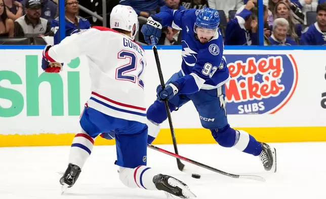 Tampa Bay Lightning center Gage Goncalves (93) gets off a shot against Montréal Canadiens defenseman Kaiden Guhle (21) during the second period in Game 7 of an NHL hockey Stanley Cup first-round playoff series, Sunday, May 3, 2026, in Tampa, Fla. (AP Photo/Chris O'Meara)