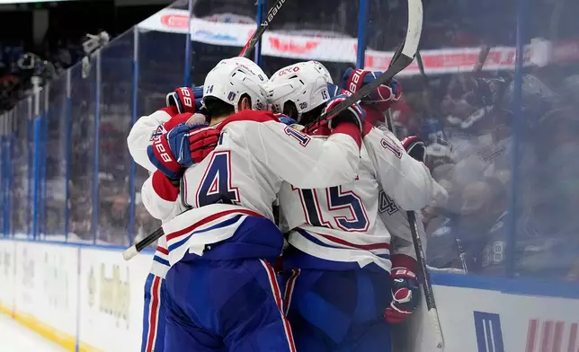 Montréal Canadiens center Alex Newhook (15) is mobbed by teammates, including Nick Suzuki (14) after scoring against the Tampa Bay Lightning during the third period in Game 7 of an NHL hockey Stanley Cup first-round playoff series, Sunday, May 3, 2026, in Tampa, Fla. (AP Photo/Chris O'Meara)