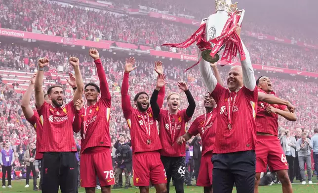 FILE - Liverpool's manager Arne Slot holds the winner's trophy as he celebrates with the players after the English Premier League soccer match between Liverpool and Crystal Palace at the Anfield stadium in Liverpool, England, Sunday, May 25, 2025. (AP Photo/Jon Super, File)