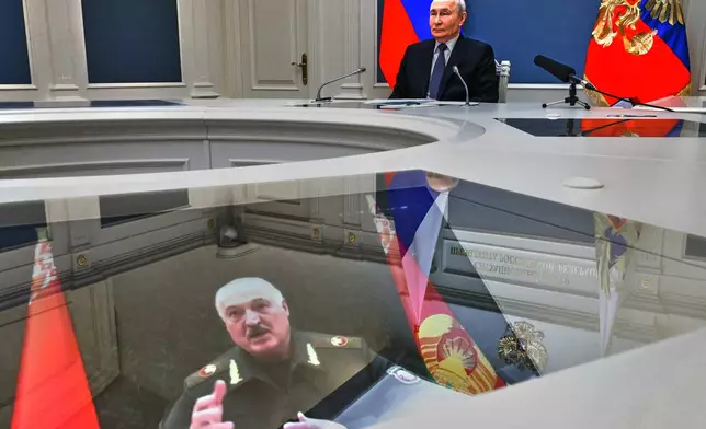 Russian President Vladimir Putin and his Belarusian counterpart Alexander Lukashenko, seen at the screen, take part in a video call as part of joint nuclear drills at the Presidential Situation Centre at the Kremlin in Moscow, Thursday, May 21, 2026. (Mikhail Metzel/Sputnik, Kremlin Pool Photo via AP)