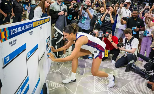 FILE - TCU guard Donovyn Hunter (4) places the team placard on the bracket board after the second round of the NCAA college basketball tournament March 22, 2026, Fort Worth, Texas. (AP Photo/Jessica Tobias, File)