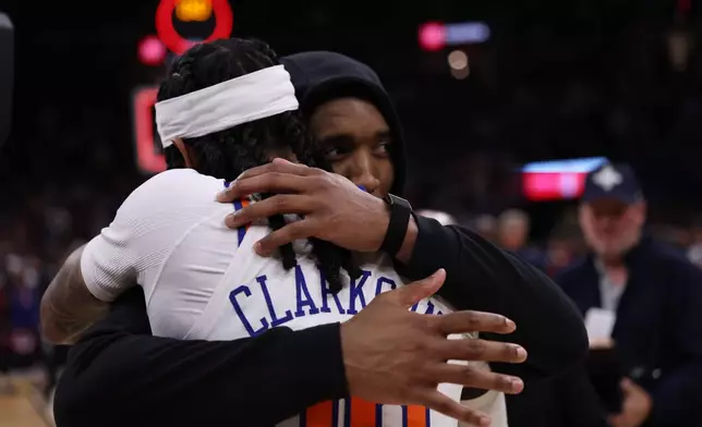 Cleveland Cavaliers guard Donovan Mitchell, right, hugs New York Knicks guard Jordan Clarkson (00) after Game 4 in the Eastern Conference finals NBA basketball playoffs series in Cleveland, Monday, May 25, 2026. (AP Photo/Tim Phillis)