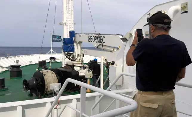 A passenger on the the hantavirus-stricken cruise ship, MV Hondius, takes a photo of the ship's weighing anchor in Praia, during the voyage to Spain's port of Tenerife, May 6, 2026. (AP Photo)
