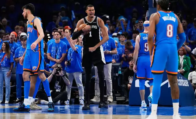 San Antonio Spurs forward Victor Wembanyama (1) celebrates after a dunk during the second overtime of Game 1 in a third-round NBA basketball playoffs series against the Oklahoma City Thunder Monday, May 18, 2026, in Oklahoma City. (AP Photo/Tony Gutierrez)