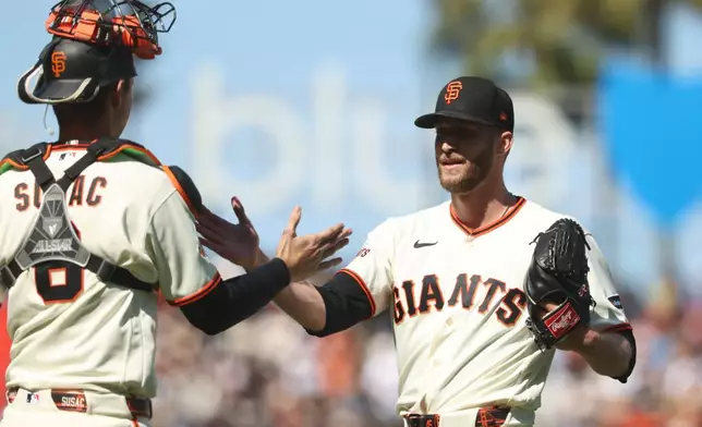 San Francisco Giants' Caleb Kilian, right, celebrates with Daniel Susac, left, after their team's victory over the Chicago White Sox in a baseball game in San Francisco, Sunday, May 24, 2026. (AP Photo/Jed Jacobsohn)