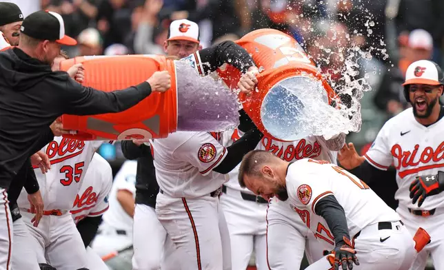Baltimore Orioles' Colton Cowser (17) celebrates with teammates after hitting a walkoff three-run home run during the ninth inning in the first baseball game of a doubleheader against the Detroit Tigers, Sunday, May 24, 2026, in Baltimore. (AP Photo/Stephanie Scarbrough)