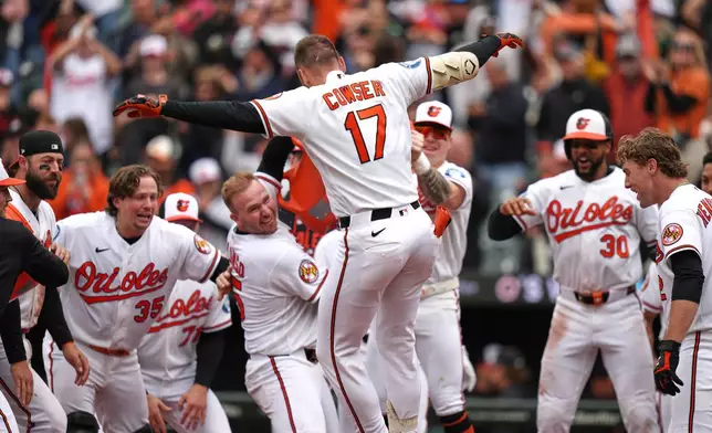 Baltimore Orioles' Colton Cowser (17) celebrates with teammates after hitting a walkoff three-run home run during the ninth inning in the first baseball game of a doubleheader against the Detroit Tigers, Sunday, May 24, 2026, in Baltimore. (AP Photo/Stephanie Scarbrough)